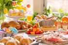 Een heerlijke Nederlandse paastafel met croissants, fruit, paasdecoraties, en een assortiment van hartige en zoete gerechten, perfect voor Pasen, waar ter wereld je ook bent!